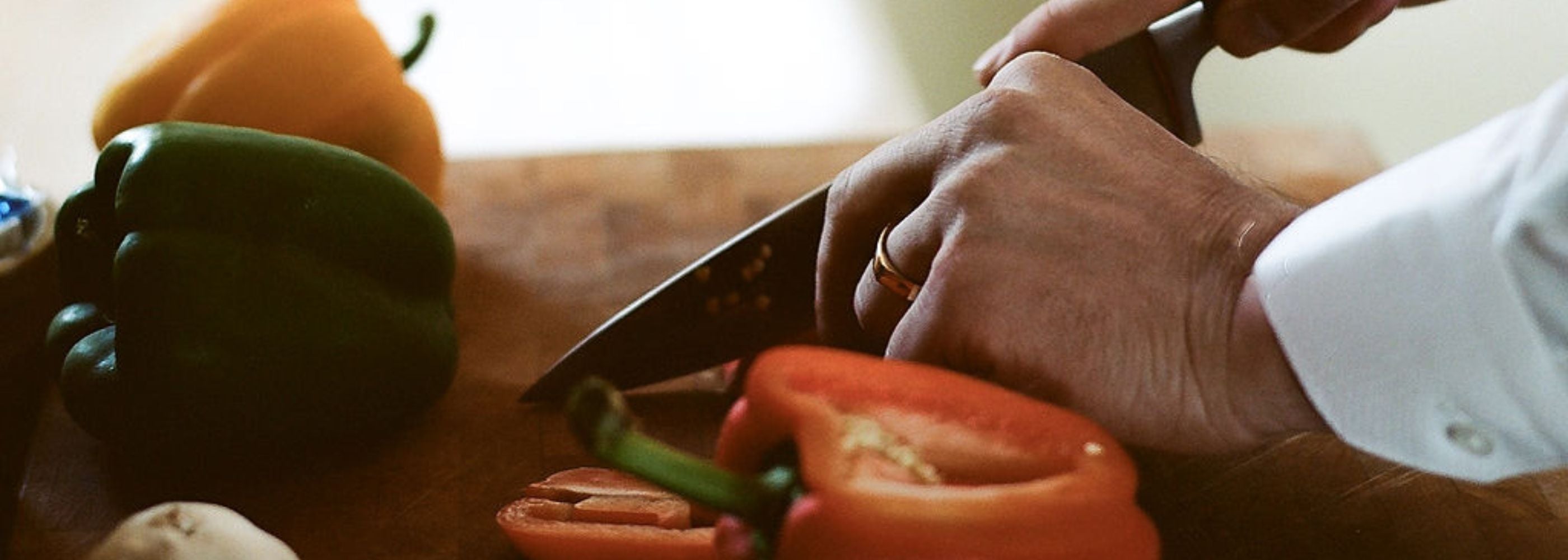 a man chop vegetables, his gold wedding ring is visible