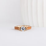 round cut lab grown diamond set beautifully in yellow gold and is shown with american elm wood inlays