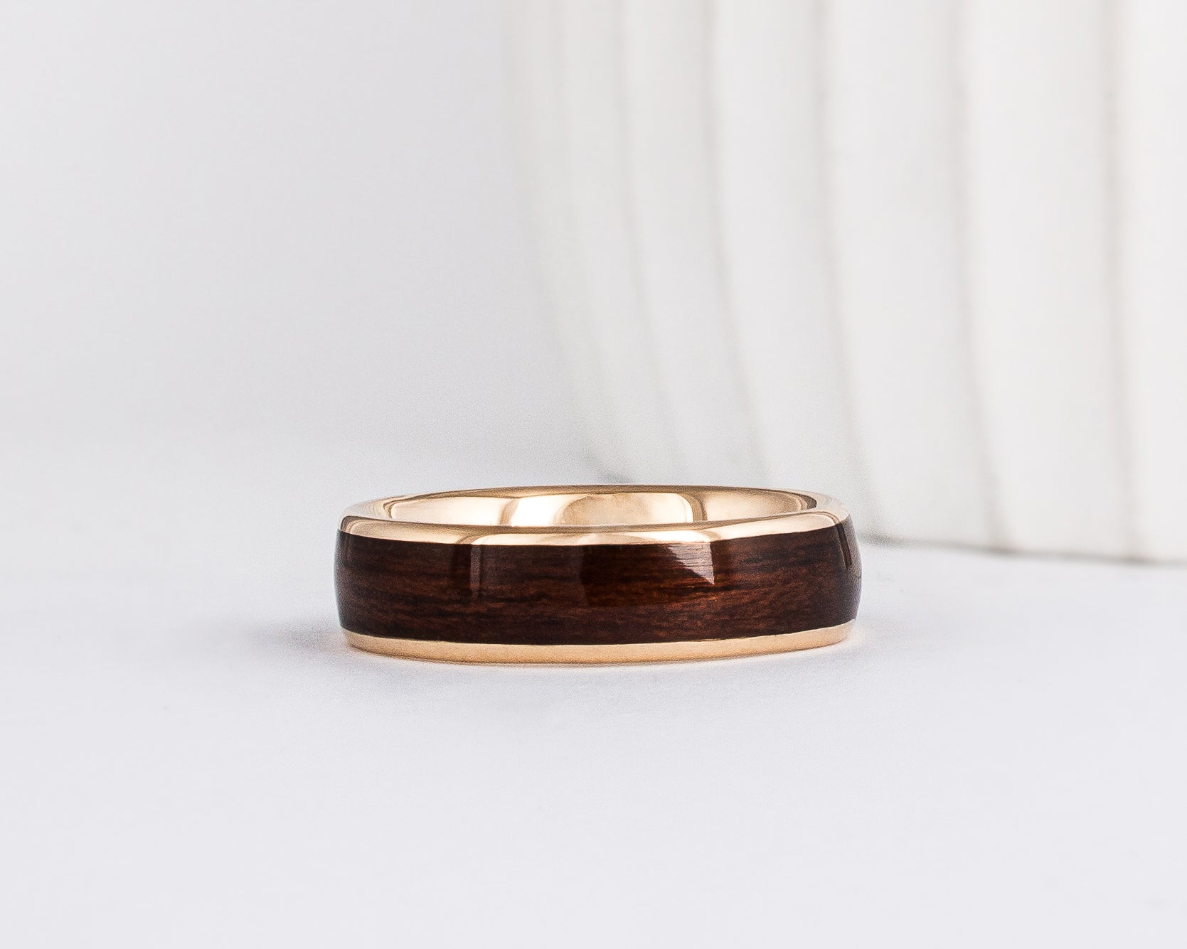 a wood ring with yellow gold and a wide dark english oak wood inlay