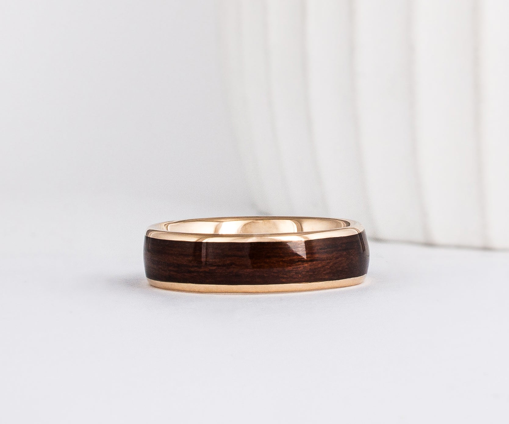 a wood ring with yellow gold and a wide dark english oak wood inlay