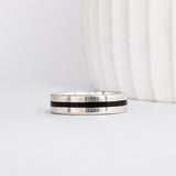 a modern wooden wedding ring for men or women featuring white gold, a flat profile and a central inlay of dark black ebony wood
