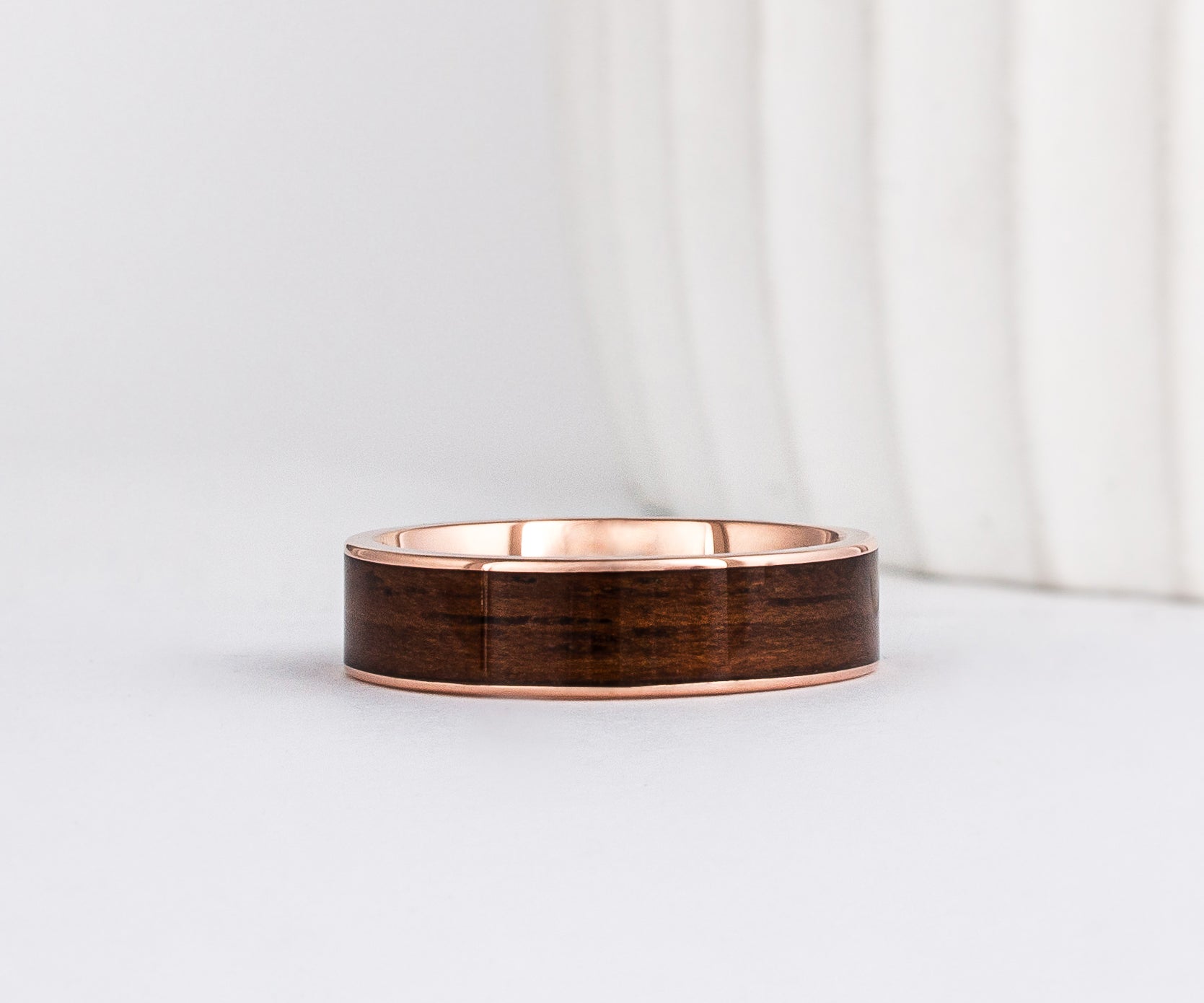 a 6mm gold and wood ring made with rose gold and english oak wood inlay