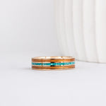 a yellow gold ring with wood inlay made from red alder with a central inlay of sleeping beauty turquoise