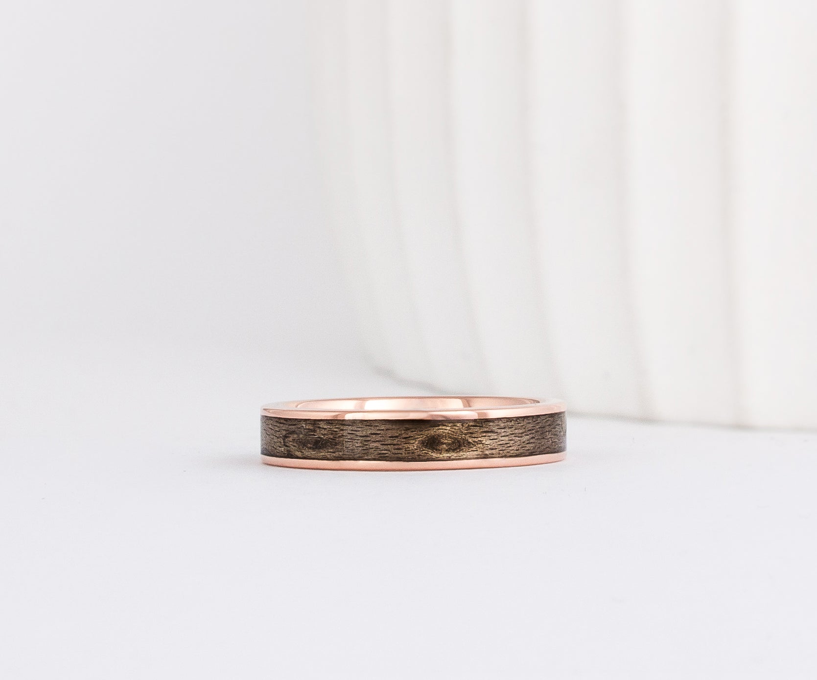 rose gold 4mm band with a straight edge profile with thin gold borders outlining a gray inlay of maple wood