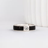 white gold 6mm band with a gypsy set moissanite with dark ebony wood inlays