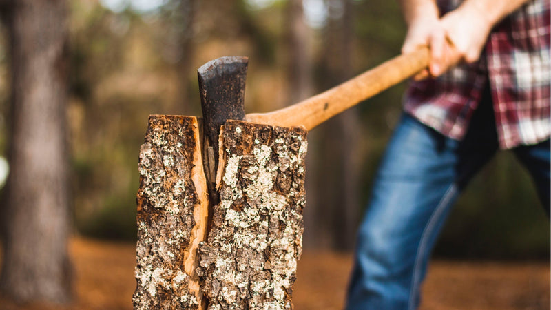 a man splits a log with an axe