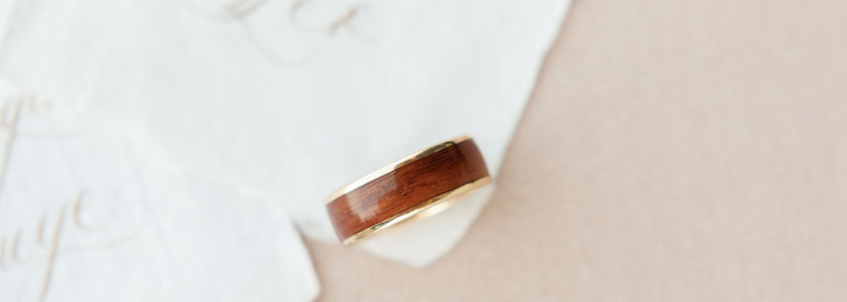 a yellow gold band with a wide wood inlay