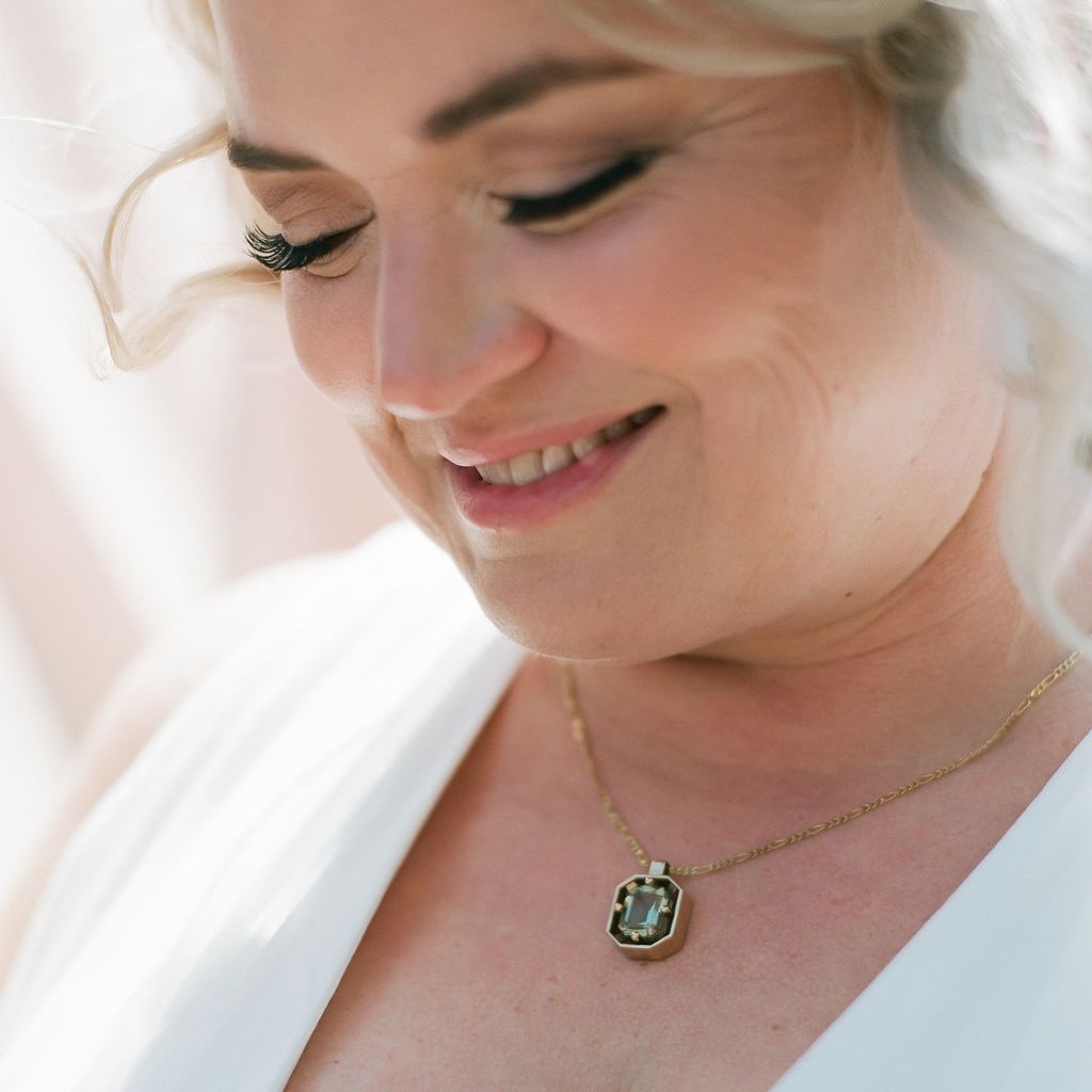 A woman wears a custom prasiolite pendant made by Northwood Jewelry