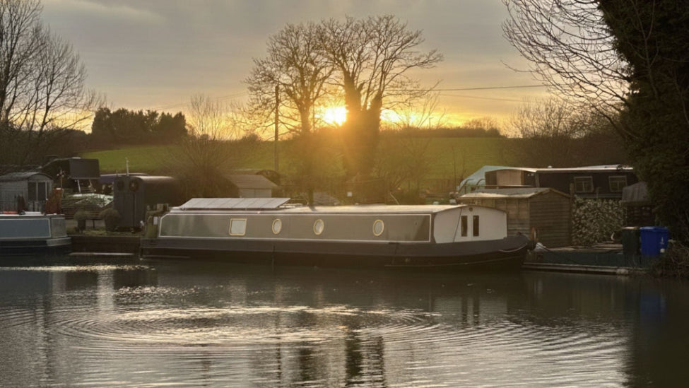 Barge on a canal with a sunset in the background