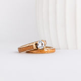 a wood wedding ring set made from yellow gold, american elm wood inlays, and a moissanite solitaire