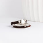 a wood wedding ring set made from white gold, walnut burl wood inlays, and a moissanite solitaire