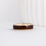 a wood ring with yellow gold and a wide dark english oak wood inlay
