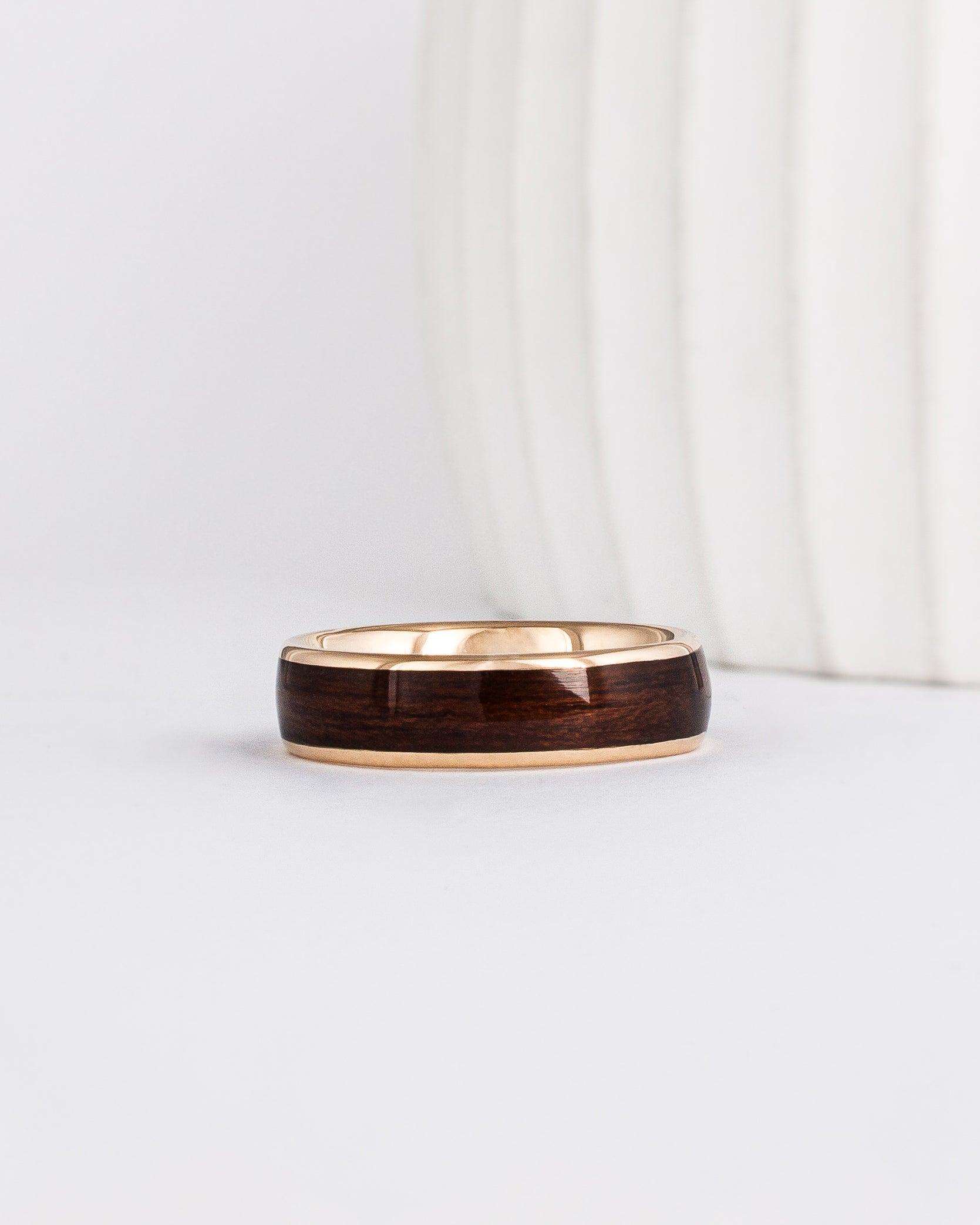 a wood ring with yellow gold and a wide dark english oak wood inlay