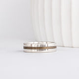 a modern wooden wedding ring for men or women featuring white gold, a flat profile and a central inlay of greyed Maplewood