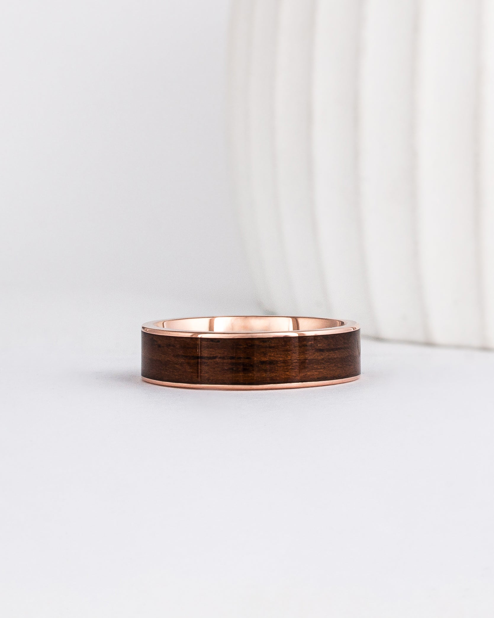 a 6mm gold and wood ring made with rose gold and english oak wood inlay