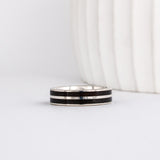 white gold band with straight-styled sleek edge design is inlaid with black ebony wood