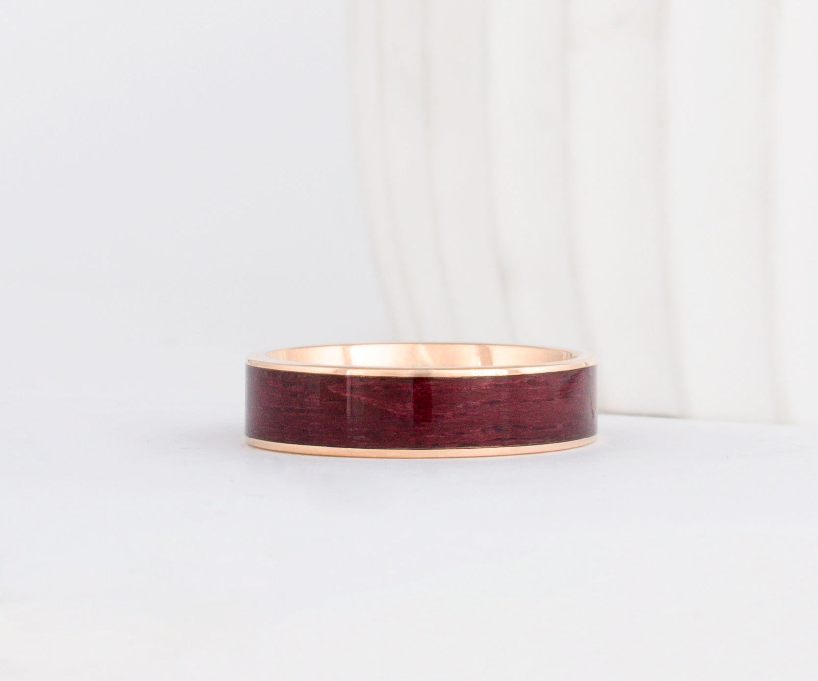 a yellow gold peyton style ring with rich purpleheart wood inlay