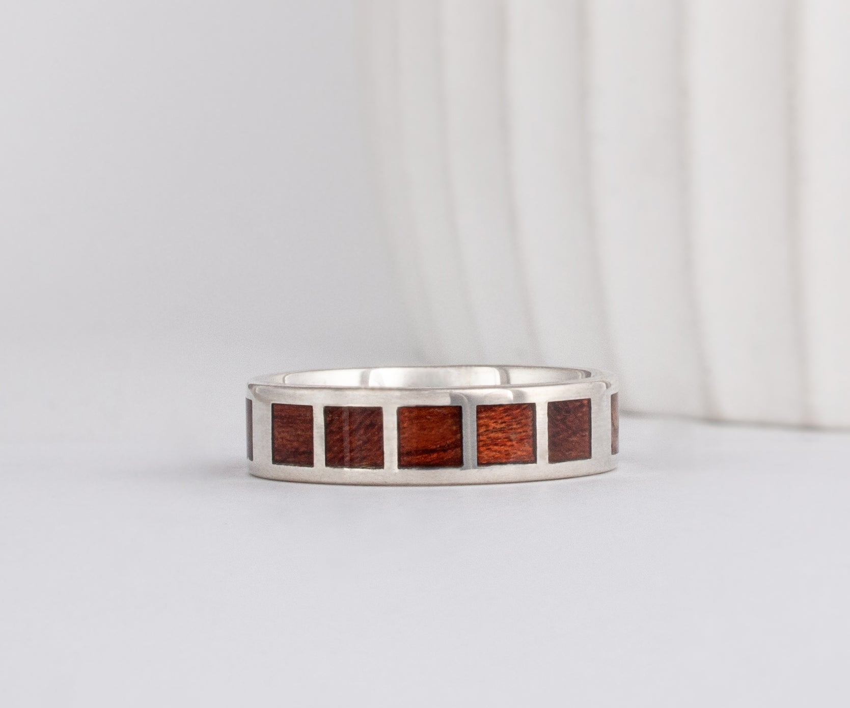 white gold modern flat profile band with Santos rosewood inlay in square patterns around band