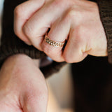man folding up cuff of sweater while wearing a rose gold nature inspired ring